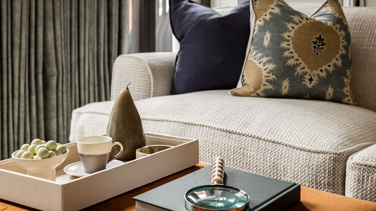 Stylish living room with neutral textured seating, decorative cushions and accessories illustrating rental-ready property furnishing for Dubai homeowners.