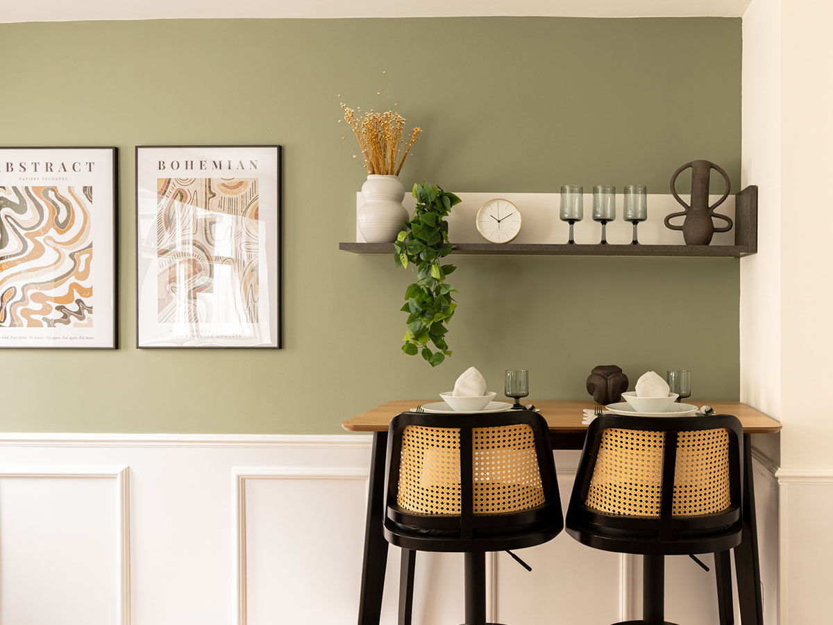Modern interior design Dubai dining nook with bar stools, art, and shelf décor, showing stylish furnishing services in Dubai and interior design services in Dubai