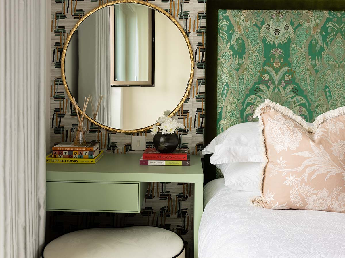 Stylish bedroom with patterned headboard, round mirror, and décor accents, showcasing elegant Airbnb furnishing service and modern design details