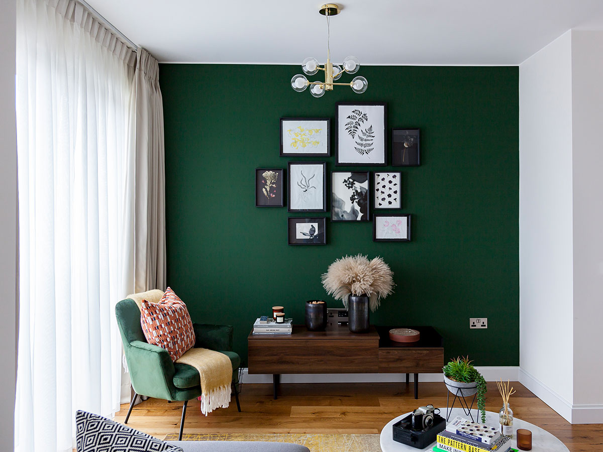 Stylish living room with green feature wall and modern décor, showcasing Build-to-Rent furniture packages for developers and investors in Dubai